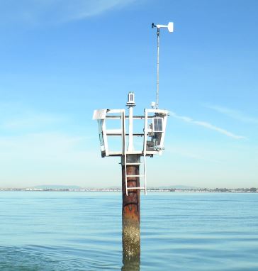A weather antenna mounted on a lookout in the water on a clear summer day