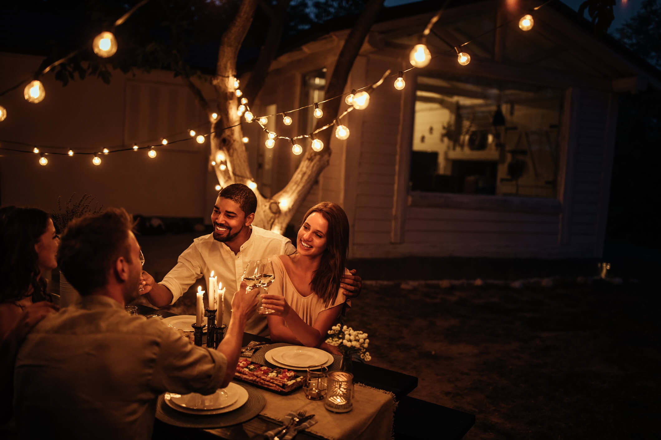 a group of friends enjoying a backyard party in the cool evening