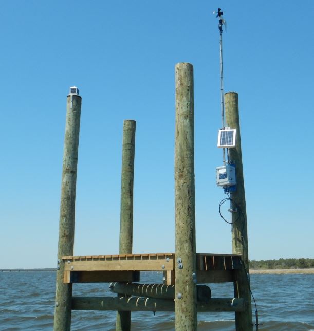 A weather antenna with solar panel in a lake on a dock in the water