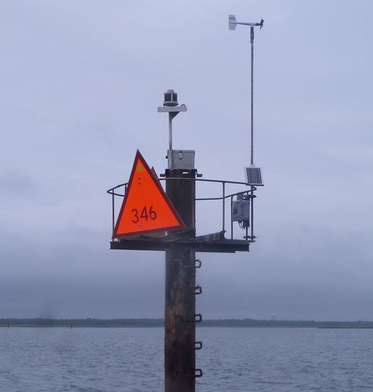 A weather antenna installed at the top of a stand on a lake