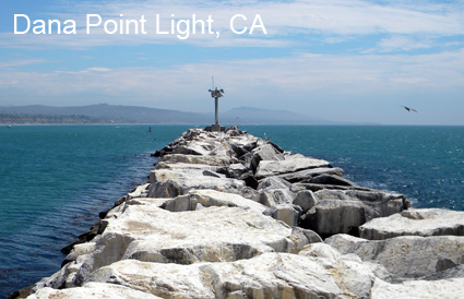 A rock shore with a weather antenna at the end in Dana Point Light, CA